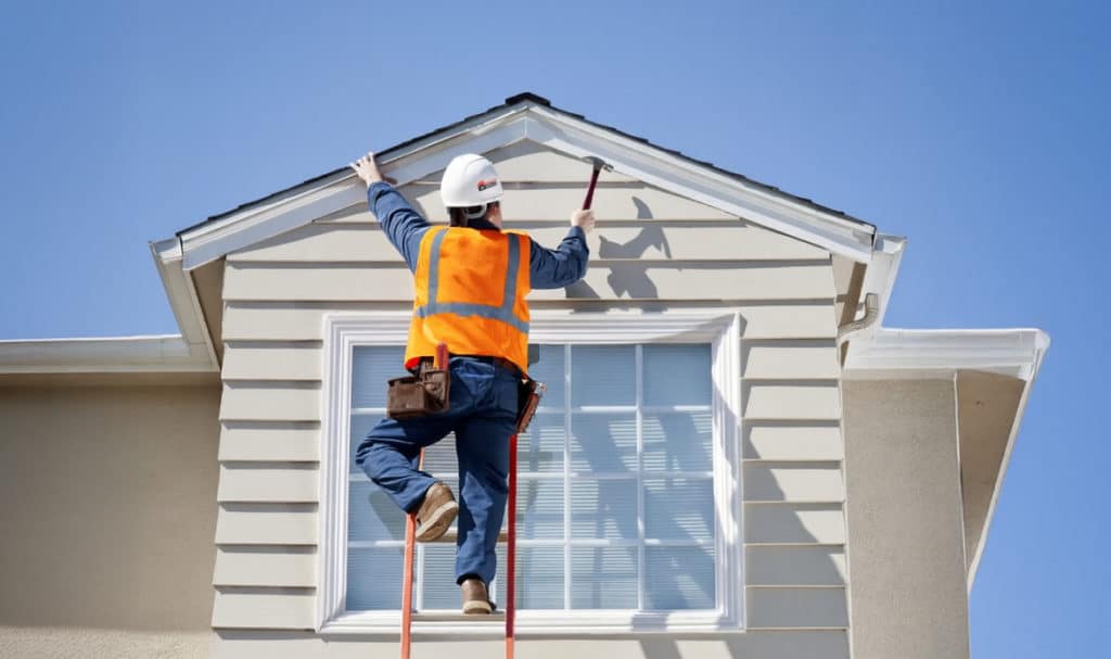 Contractor working on a Portland home exterior during a roofing or siding project with financing options available
