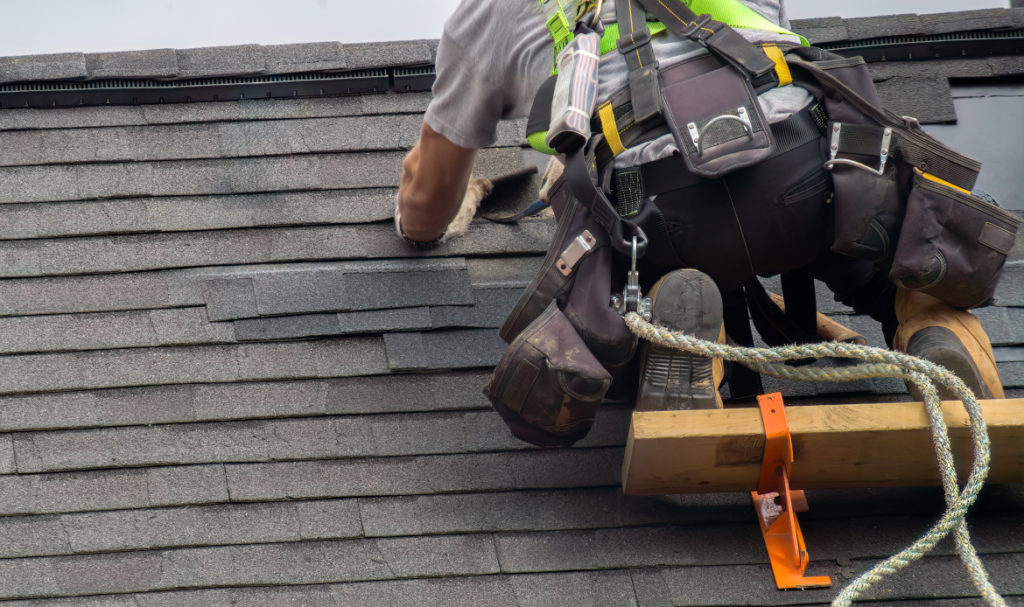 PDX Roofing and Siding professional repairing shingles on a residential roof in Portland