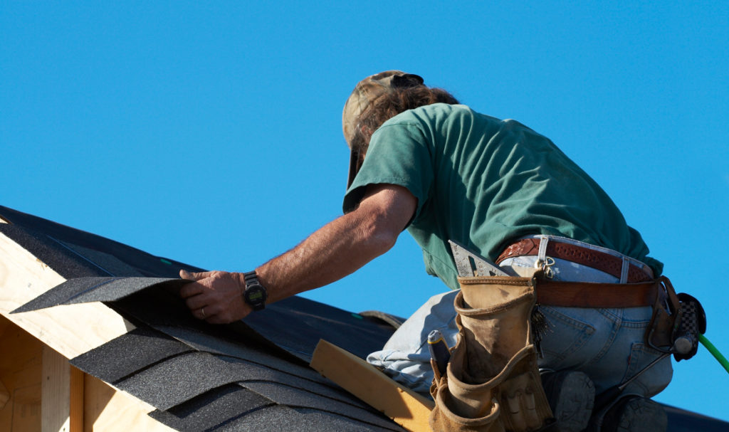 Homeowner performing DIY roof maintenance on a residential roof in Portland