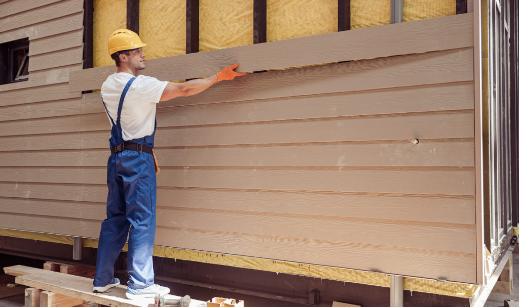 PDX Roofing and Siding professional measuring siding on a residential home in Portland