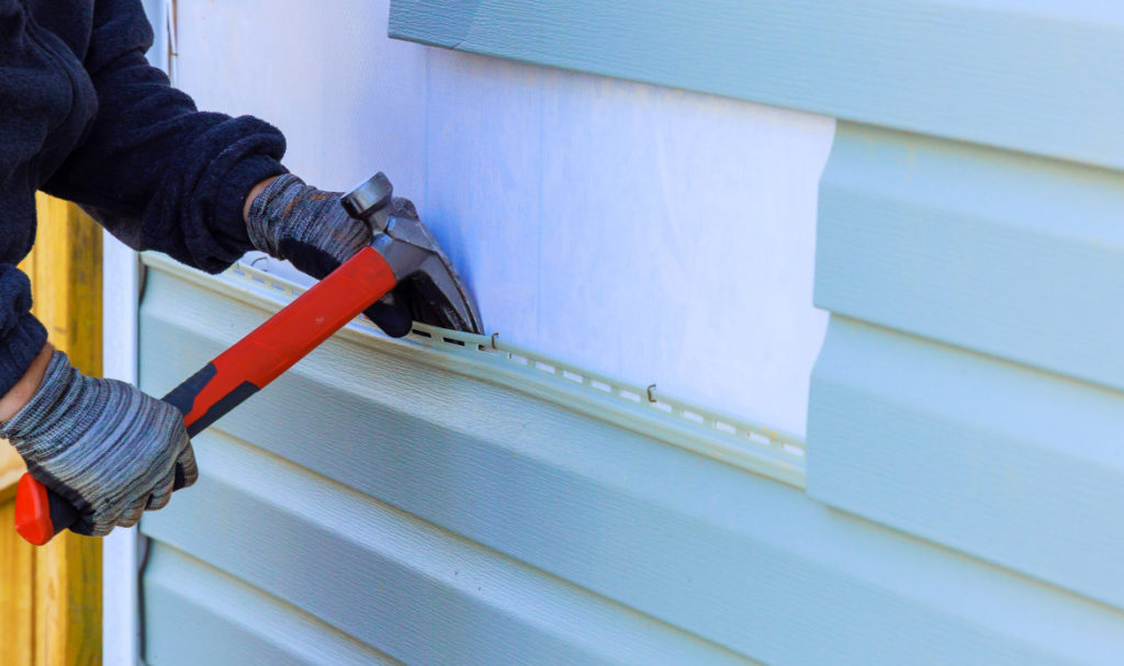 Contractor installing siding panels on a Portland home during a siding replacement project