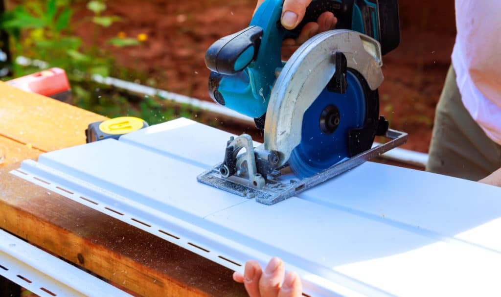 Contractor cutting siding material for a Portland home exterior with mixed textures and colors