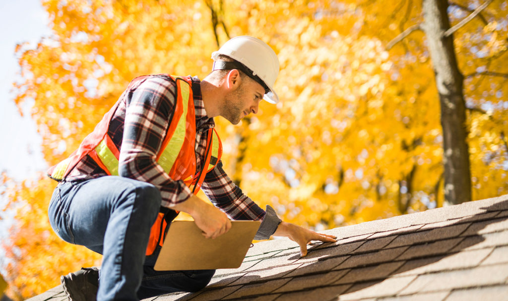 Roofing professional inspecting a residential roof in Portland to assess repair or replacement needs