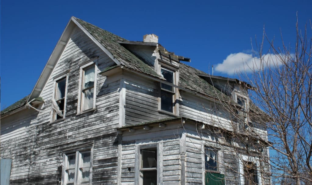 Older Portland home showing roof and siding wear caused by rain, wind, and changing temperatures