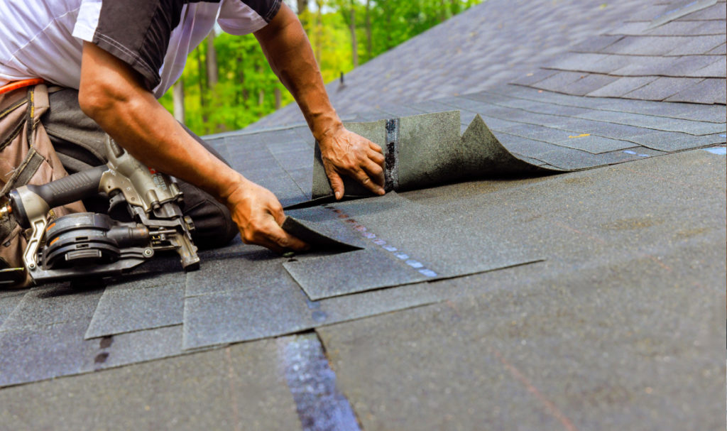 Roofer installing asphalt shingles on a residential roof in Portland designed for wet weather